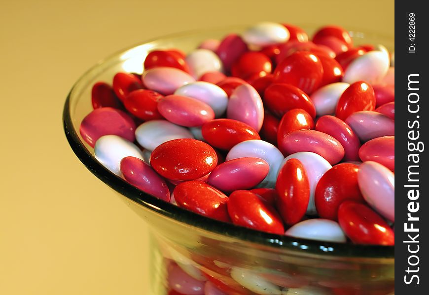 A glass dish full of pink, white and red candy set out for Valentines day. A glass dish full of pink, white and red candy set out for Valentines day