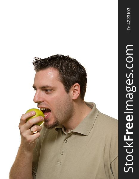 A man, holding a green apple in his hand, prepared to take a bite. A man, holding a green apple in his hand, prepared to take a bite