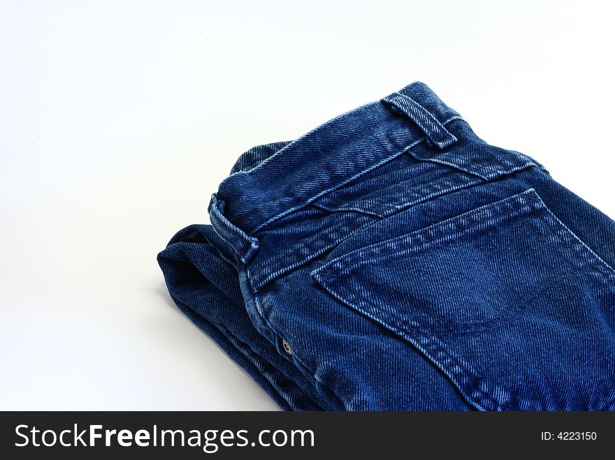 Pair of folded denim blue jeans on white background. Pair of folded denim blue jeans on white background.