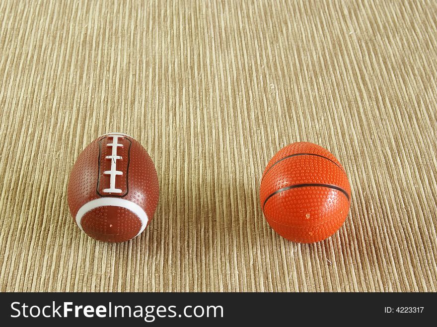 Football and basketball shaped like easter eggs on natural woven background. Looks like they're getting ready to race down the field. Football and basketball shaped like easter eggs on natural woven background. Looks like they're getting ready to race down the field.
