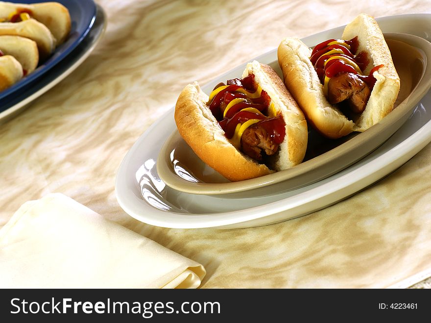 Fresh hotdogs with ketchup and mustard on buns. Fresh hotdogs with ketchup and mustard on buns.