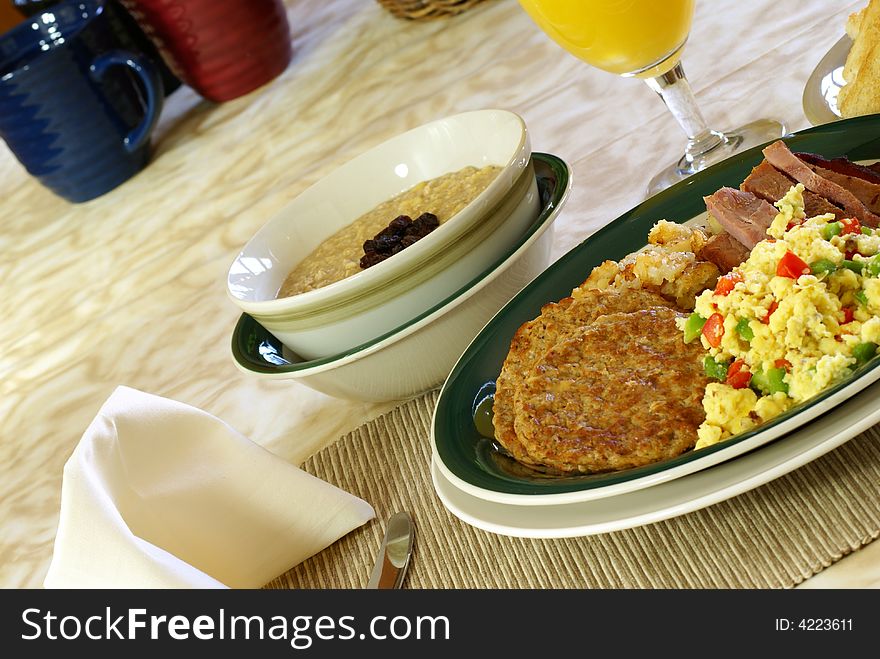 Big breakfast with eggs, ham, sausage, hash browns, toast, coffee, oatmeal and orange juice. Big breakfast with eggs, ham, sausage, hash browns, toast, coffee, oatmeal and orange juice.