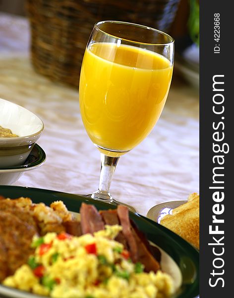 Glass of fresh orange juice at breakfast table.