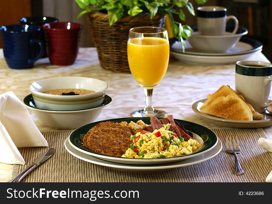 Big breakfast with eggs, ham, sausage, hash browns, toast, coffee, oatmeal and orange juice. Big breakfast with eggs, ham, sausage, hash browns, toast, coffee, oatmeal and orange juice.