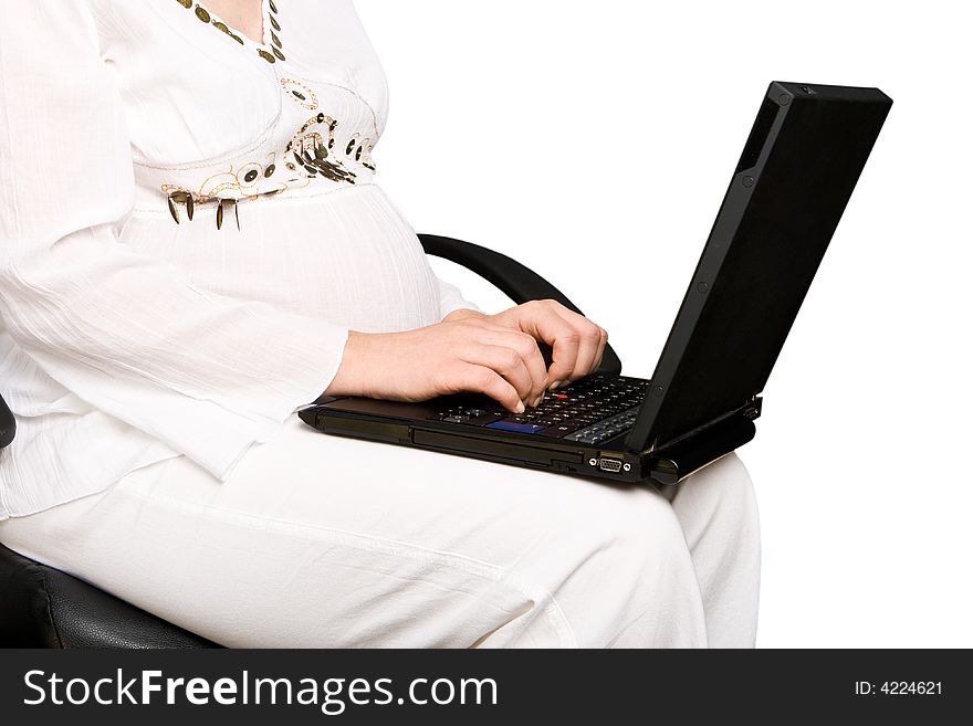 A pregnant lady typing on a laptop. A pregnant lady typing on a laptop