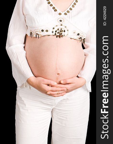 A pregnant lady holding her tummy with a black background