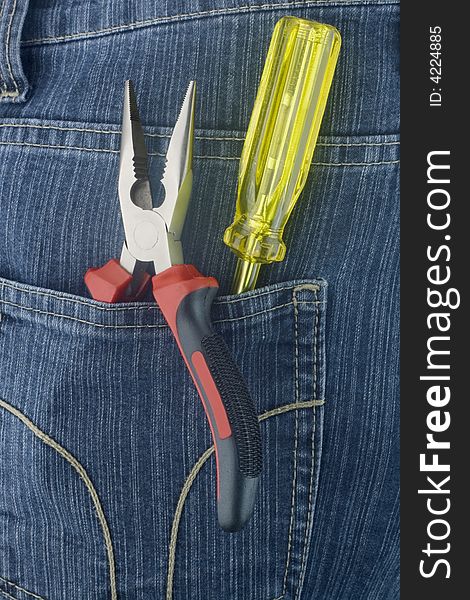 Red pliers and yellow screwdriver in a jeans pocket