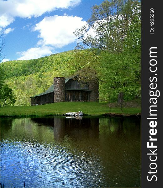 Barn with silo in front of pond. Barn with silo in front of pond.