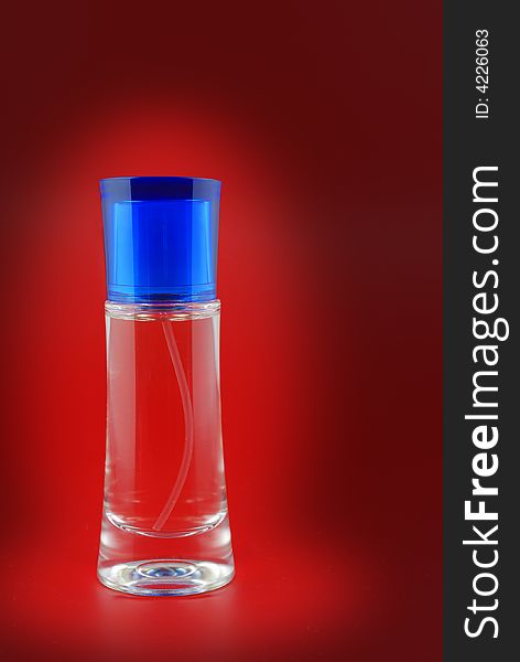 Perfume. A bottle perfume on a red background with effective illumination. Perfume. A bottle perfume on a red background with effective illumination