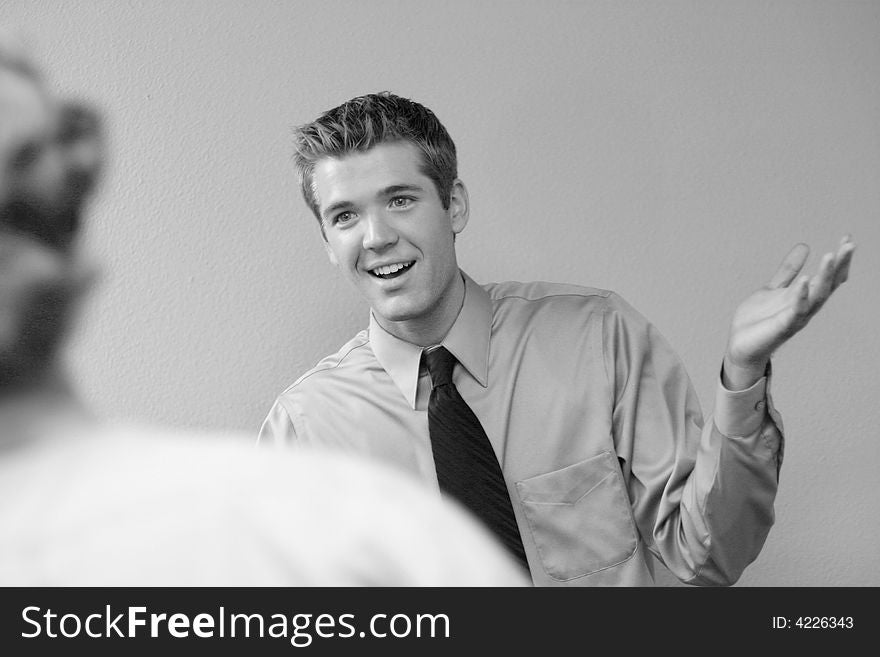 Two business men talking, one with his hand in the air, and smile on his face. Two business men talking, one with his hand in the air, and smile on his face