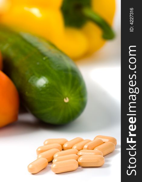 Closeup pills with vegetables pepper tomato and cucumber