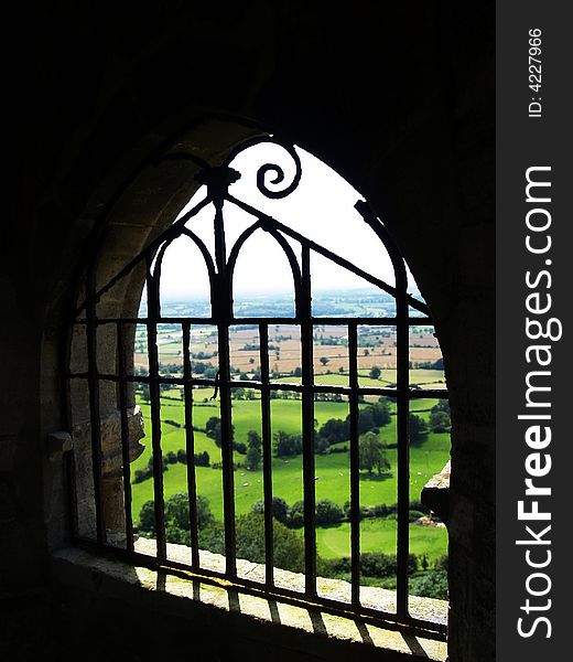 A view out of a castle or jail onto english fields.