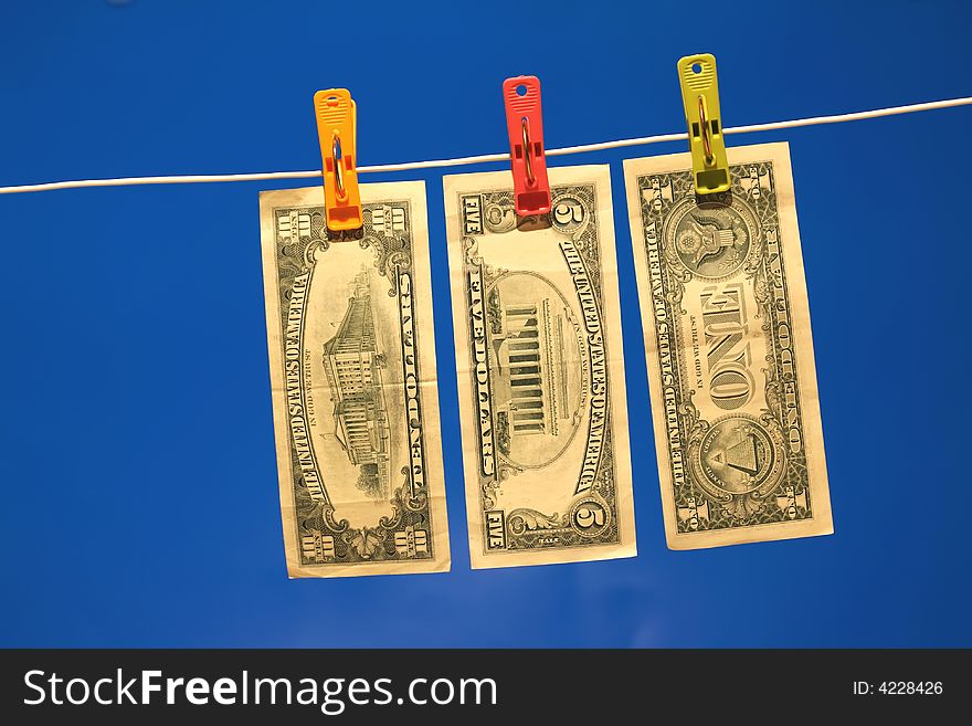 Dollar bills on a washing line, with a blue background. Dollar bills on a washing line, with a blue background