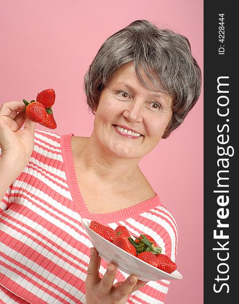 Healthy eating concept with senior holding strawberries. Healthy eating concept with senior holding strawberries