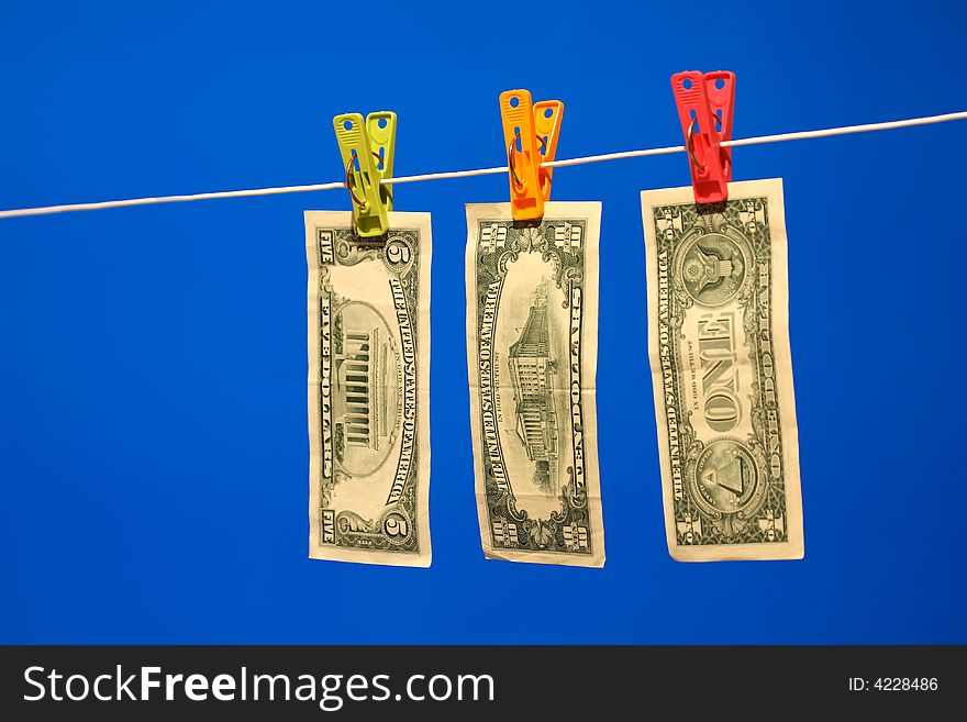 Dollar bills on a washing line, with a blue background. Dollar bills on a washing line, with a blue background