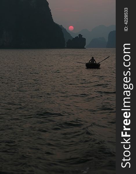 Woman in boat in halong Bay at sundown. Woman in boat in halong Bay at sundown