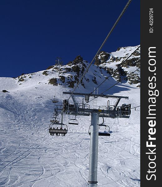 Ski lift with passengers and ski trail