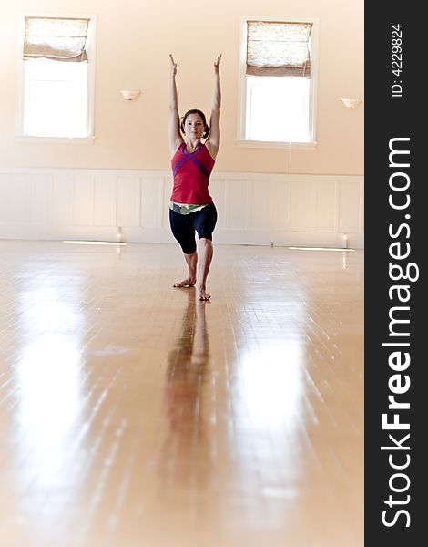 Young woman practices yoga poses in a beautiful studio.