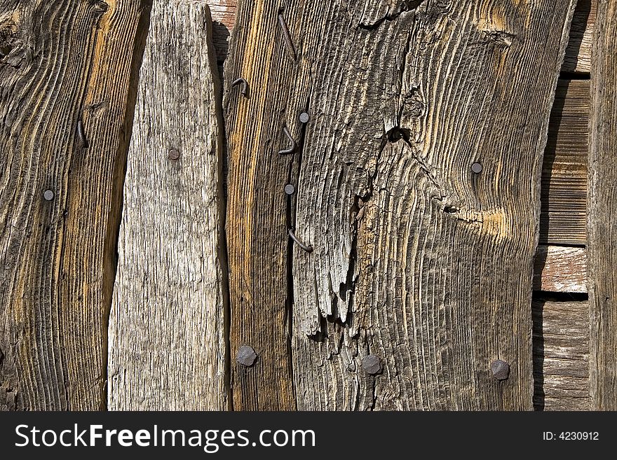 A weathered wooden wall with rusty nails. A weathered wooden wall with rusty nails