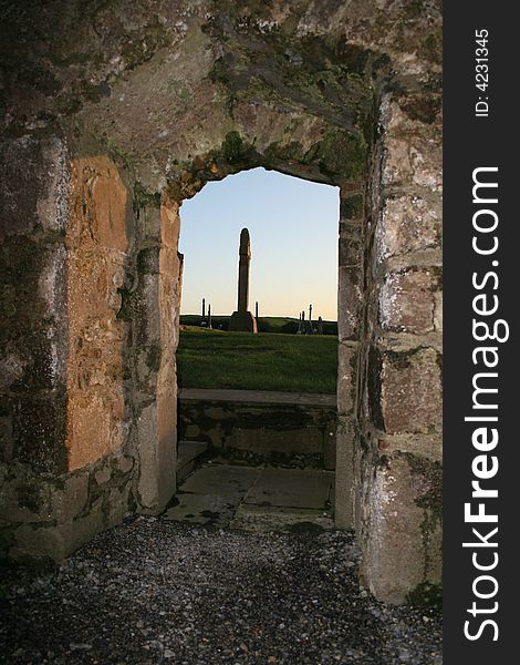 View of old cemetery through the door of a historic 10th century church ruins in Ireland. View of old cemetery through the door of a historic 10th century church ruins in Ireland