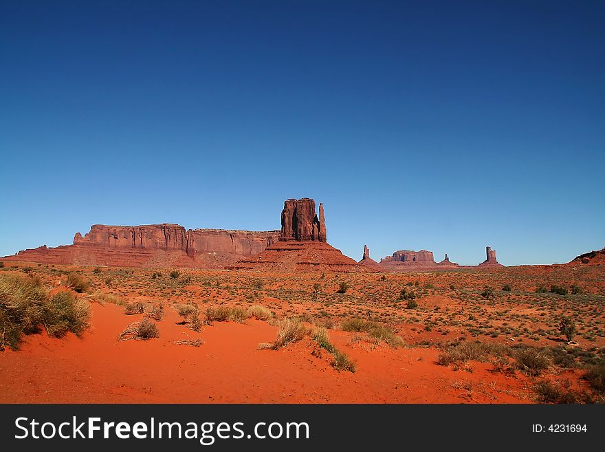 View of the red rock formations in Monument Valley with blue skyï¿½s and clouds. View of the red rock formations in Monument Valley with blue skyï¿½s and clouds