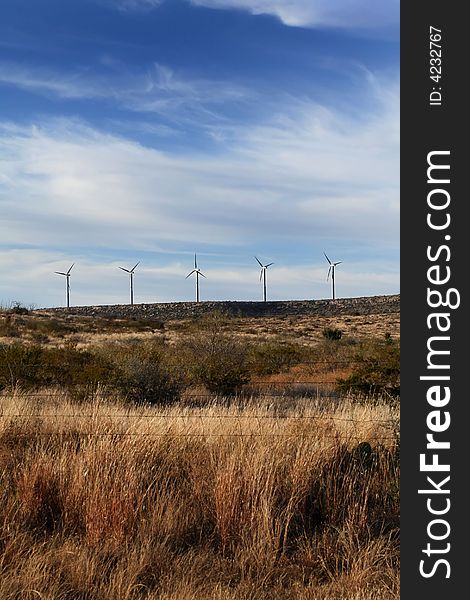 A grouping of wind turbines in a grassland setting