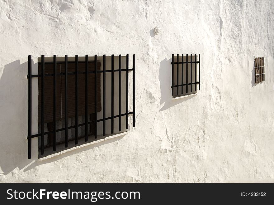 Windows with bars in a white wall. Windows with bars in a white wall