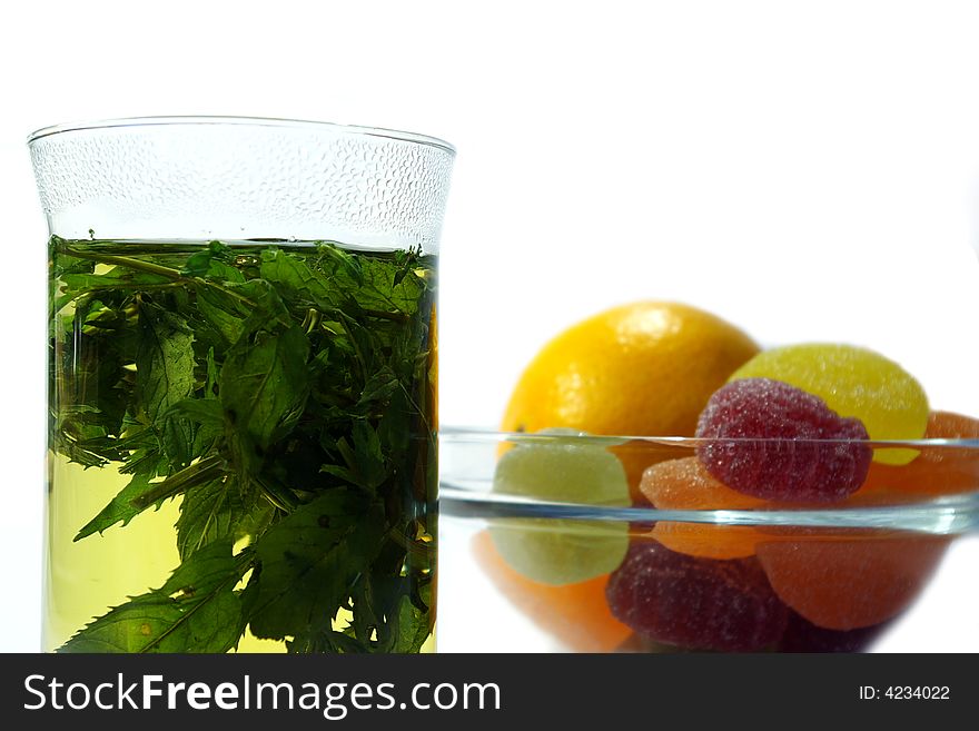 Herbal  mint tea and  fruit candy on white background