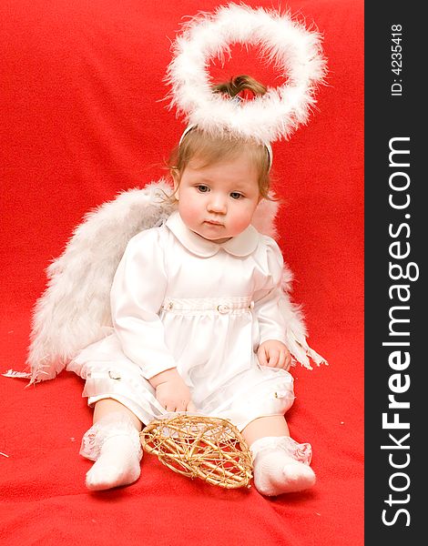 Girl an angel gets on the hip a heart on a red background