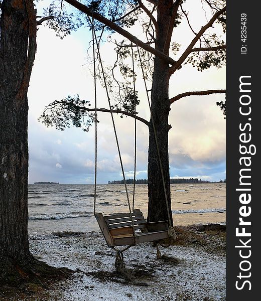 Empty swing near lake, autumn