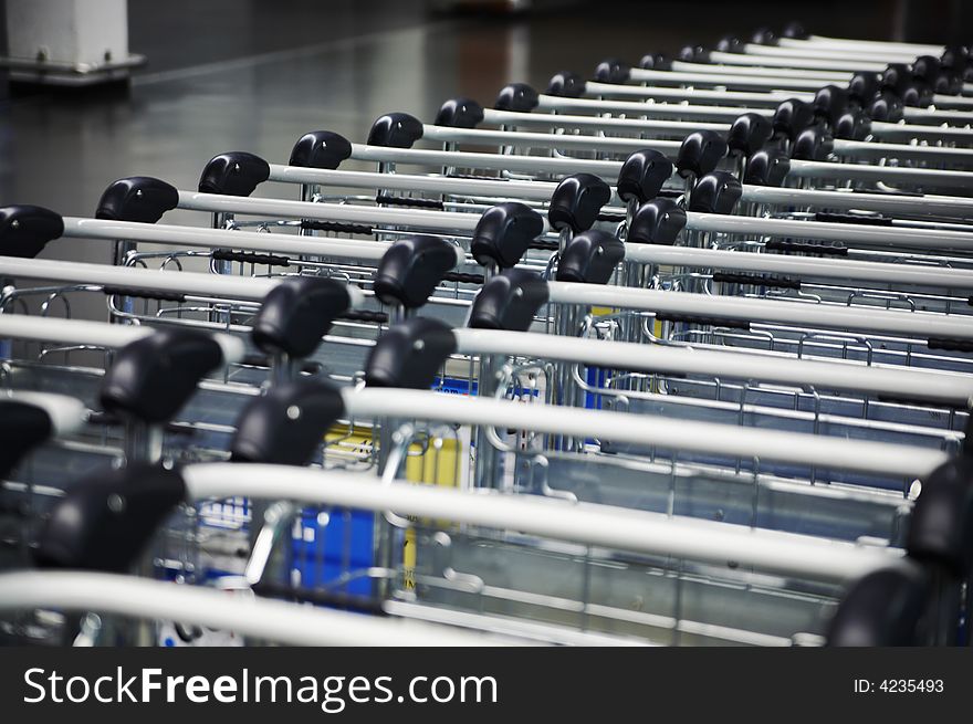 Long rows of airport luggage trolleys ,. Long rows of airport luggage trolleys ,