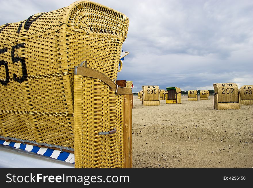 Beach wicker chairs with numbers on back in Germany near Baltic sea. Beach wicker chairs with numbers on back in Germany near Baltic sea