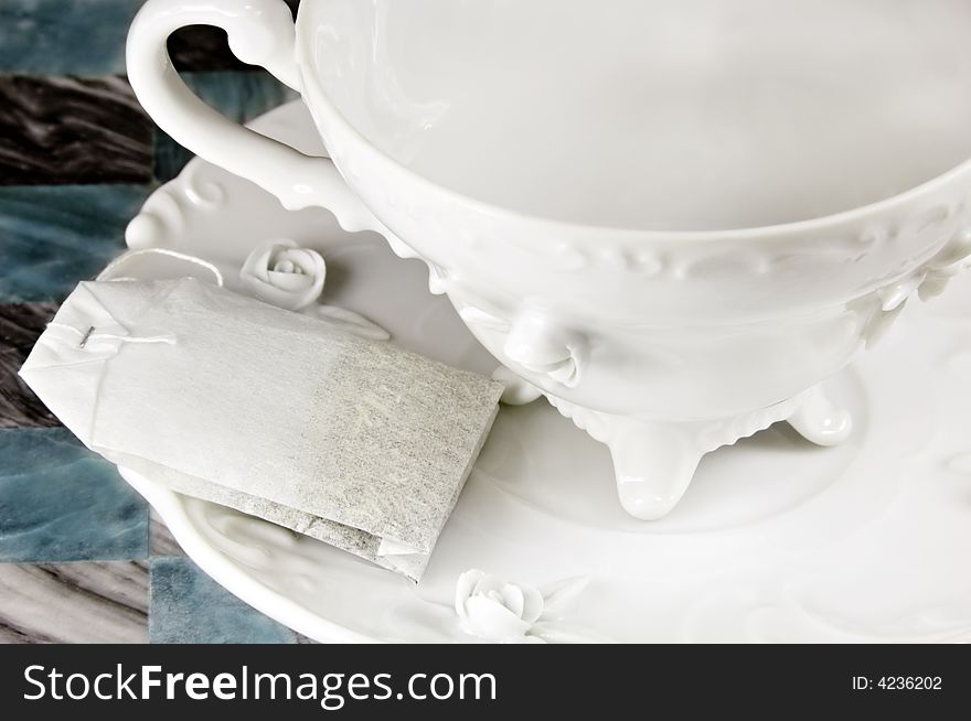 Tea bag and a white antique cup and saucer. Tea bag and a white antique cup and saucer.