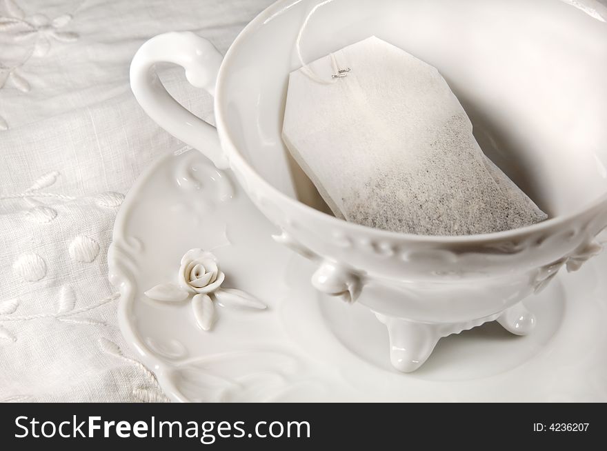 Tea bag in a white antique cup and saucer. Tea bag in a white antique cup and saucer.