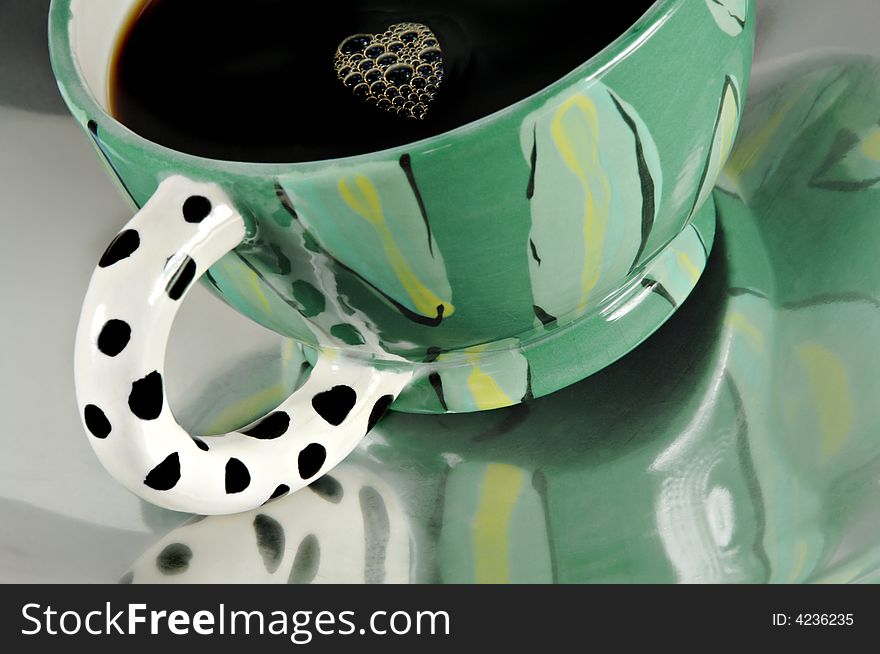 Cup of coffee reflected in a metal dish with heart shaped bubbles. Cup of coffee reflected in a metal dish with heart shaped bubbles.