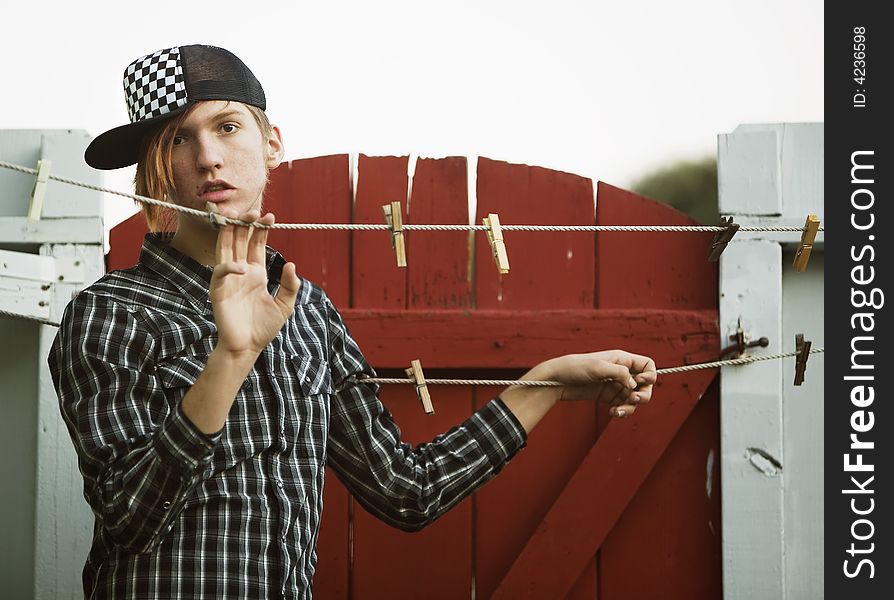 Teenage Boy Leaning On A Clothesline