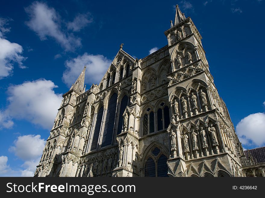 View of Salisbury Cathedral in England with blue sky and white clouds