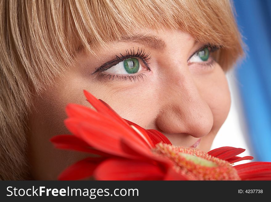 Girl's green eyes and a red flower close-up
