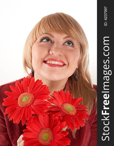 A smiling girl with red flowers looking up