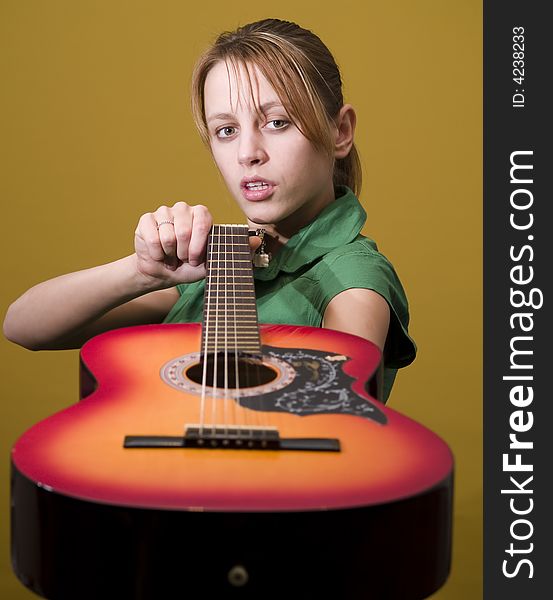 Girl in green dress with guitar in hands. Girl in green dress with guitar in hands