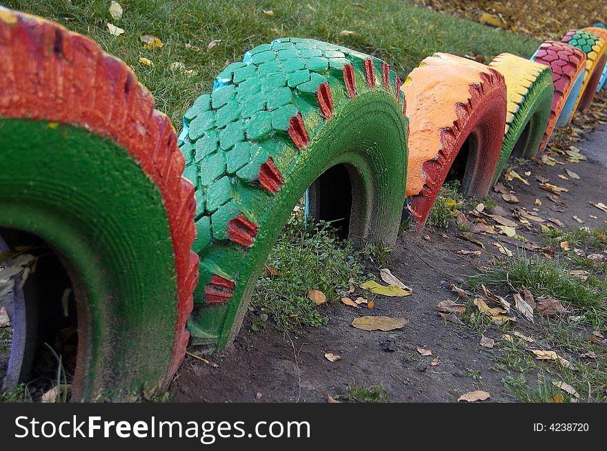 Multi-coloured wheels are dug in the ground. Multi-coloured wheels are dug in the ground