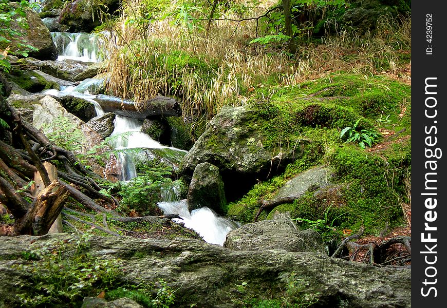 Wild mountain brook with stones and long exposure