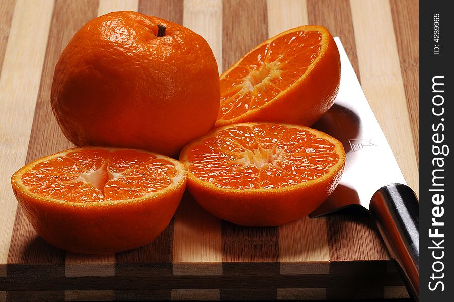 Fresh mandarin orange cutted&whole and knife on a wood cutting board. Fresh mandarin orange cutted&whole and knife on a wood cutting board