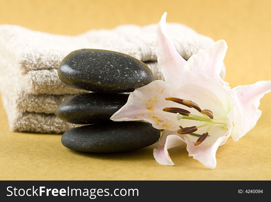 Zen Stones with white towels and fresh rose petals on earth color background