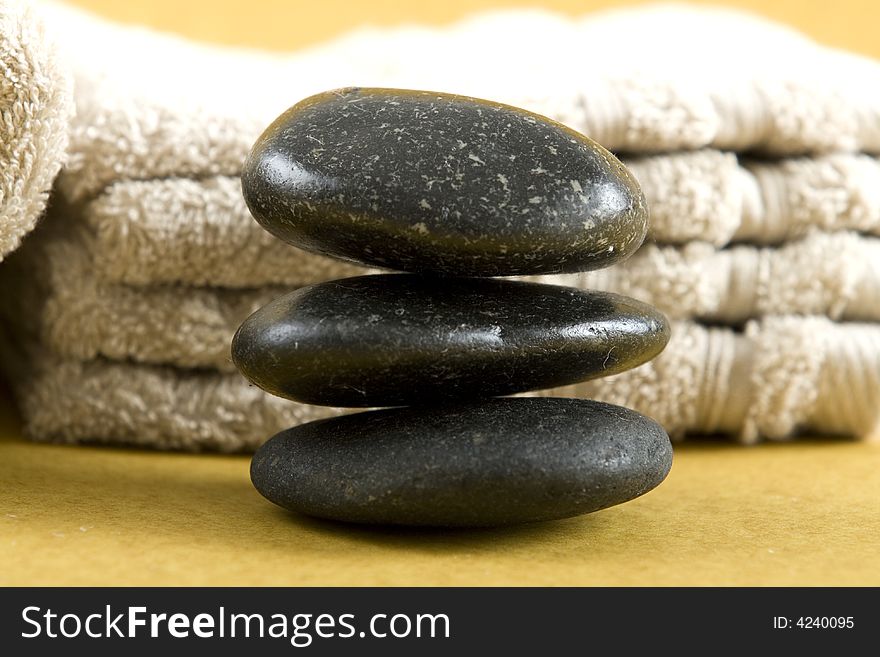 Zen Stones with white towels and fresh rose petals on earth color background