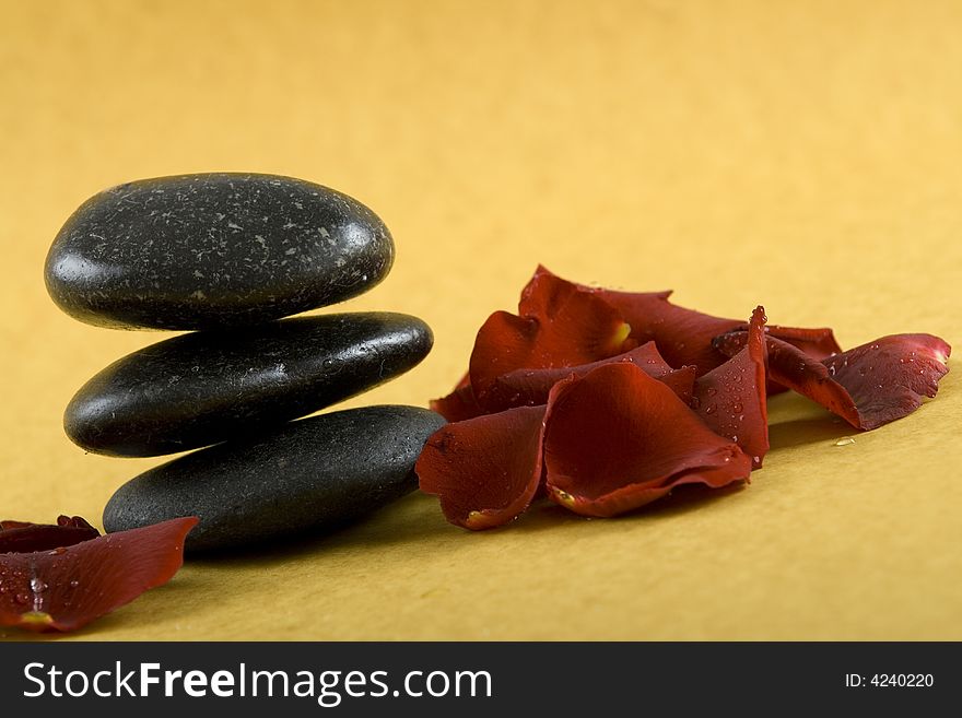 Zen Stones with white towels and fresh rose petals on earth color background