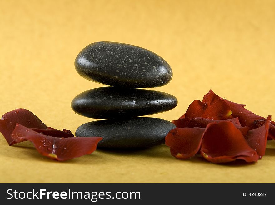 Zen Stones with white towels and fresh rose petals on earth color background