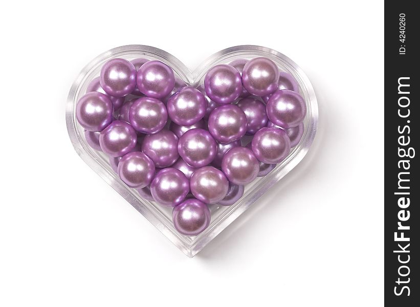 Heart-shaped plastic box with pink pearls in it. Heart-shaped plastic box with pink pearls in it.