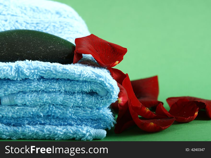 Spa products including folded towels fresh  flowers on blue background