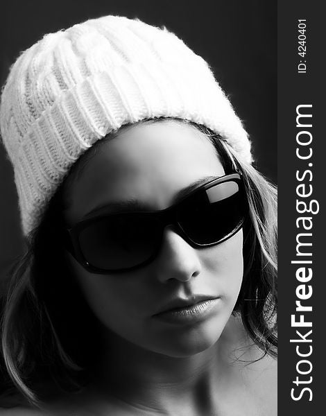 Portrait of a beautiful woman with a cap and some sunglasses against grey background. Portrait of a beautiful woman with a cap and some sunglasses against grey background